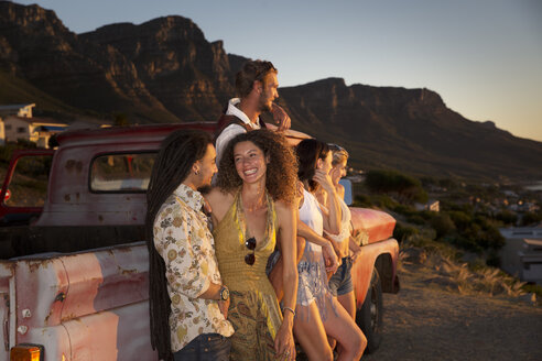 Junge Leute vor einem Pick-up-Truck an der Küste genießen den Sonnenuntergang - ZEF13917