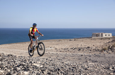 Spanien, Kanarische Inseln, Fuerteventura, älterer Mann auf Mountainbike - MFRF00851