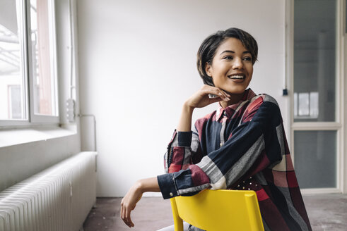 Smiling woman sitting on chair - KNSF01524