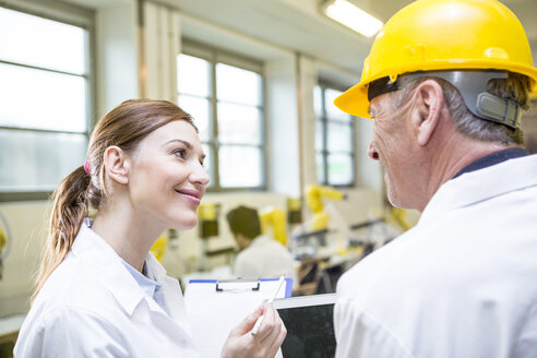 Two smiling engineers in factory - WESTF23398