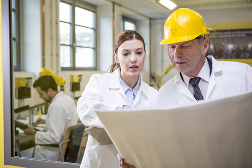 Two engineers in factory looking at plan - WESTF23402