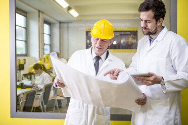 Two engineers in factory looking at plan - WESTF23403
