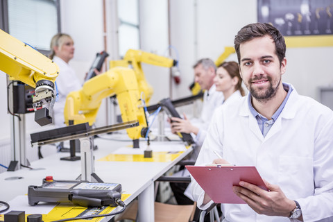 Porträt eines lächelnden Ingenieurs in einer Fabrik mit Zwischenablage, lizenzfreies Stockfoto
