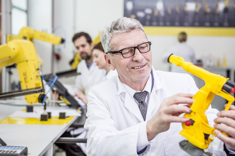 Engineer holding model of an industrial robot stock photo