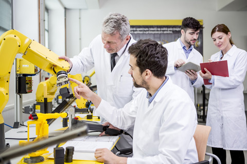 Engineers examining industrial robot stock photo