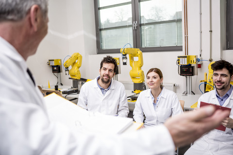 Engineers looking at boss making a speech stock photo