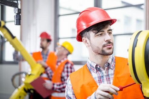 Technician working on industrial robot - WESTF23460