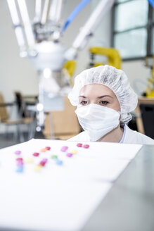 Woman watching robot handling sweets - WESTF23468