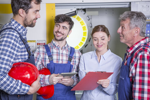 Smiling staff in factory with CNC machine in background - WESTF23474