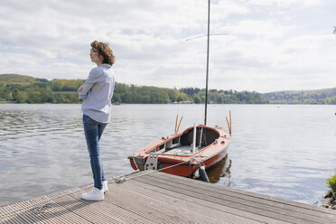 Frau steht am Steg mit vertäutem Segelboot - KNSF01542