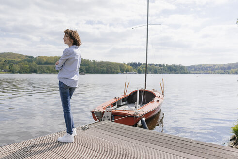 Frau steht am Steg mit vertäutem Segelboot - KNSF01542