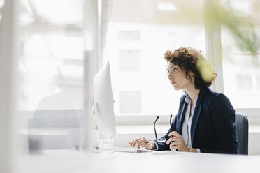 Geschäftsfrau, die im Büro arbeitet und einen Computer benutzt - KNSF01544