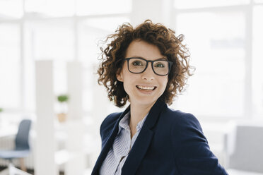 Businesswoman standing in her office, smiling - KNSF01567