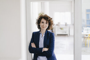 Businesswoman standing in her office with arms crossed - KNSF01576