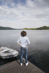 Woman standing on jetty with moored boat - KNSF01611