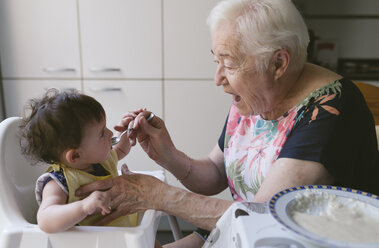 Großmutter füttert kleines Mädchen in der Küche - GEMF01679