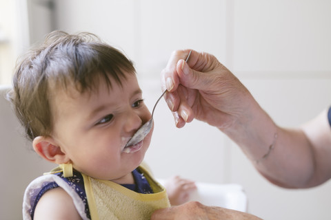 Porträt eines kleinen Mädchens nach der Fütterung durch die Großmutter, lizenzfreies Stockfoto