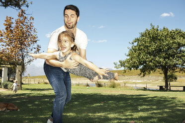 Father playing with daughter in garden - ZEF13947
