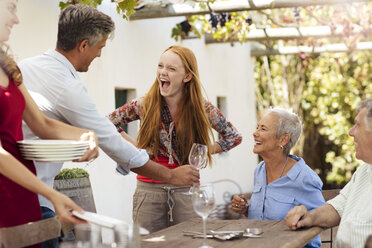 Happy family setting table outside for lunch - ZEF13964