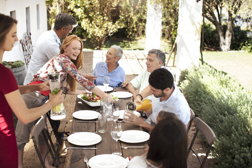 Happy family preparing lunch on garden table - ZEF13967