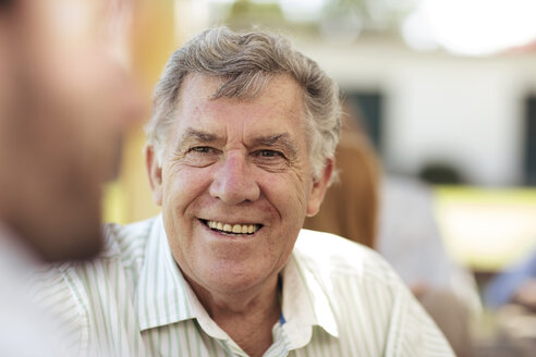 Lächelnder älterer Mann beim geselligen Beisammensein auf einer Gartenparty - ZEF13980