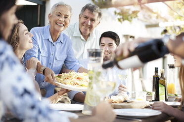 Glückliche Familie beim gemeinsamen Mittagessen im Freien - ZEF13988