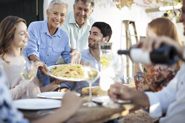 Happy family having lunch together outside - ZEF13989