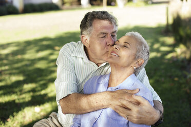 Senior man kissing his wife in garden - ZEF13992