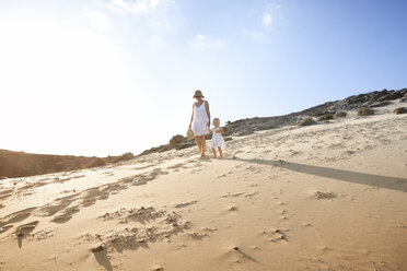 Spain, Fuerteventura, mother walking with daughter on the beach - MFRF00860