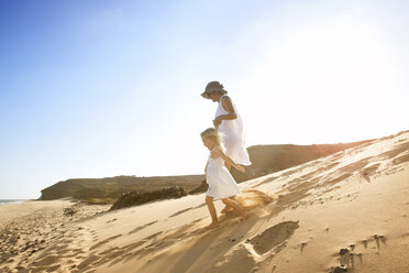 Spanien, Fuerteventura, Mutter läuft mit Tochter am Strand - MFRF00861