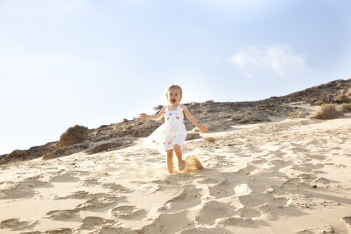Spanien, Fuerteventura, Mädchen läuft am Strand die Düne hinunter - MFRF00863