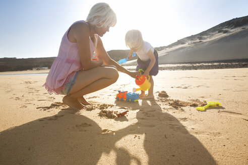 Spain, Fuerteventura, mother and daughter playing on the beach - MFRF00869