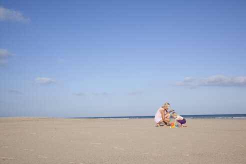 Spanien, Fuerteventura, Mutter und Tochter spielen am Strand - MFRF00870