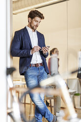 Geschäftsmann benutzt Mobiltelefon im Büro - PESF00654