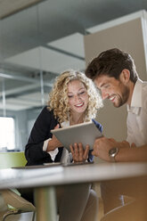 Two colleagues sharing tablet in office - PESF00664