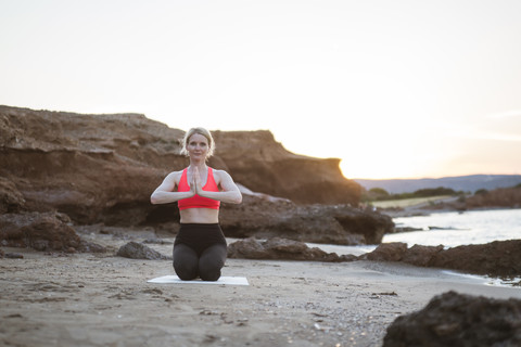 Greece, Crete, woman practicing yoga on the beach stock photo