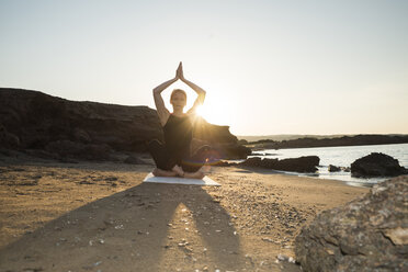 Greece, Crete, woman practicing yoga on the beach at sunset - CHPF00405