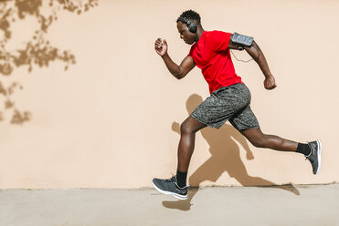 Energized sportsman at city sports stadium listens to his favorite music  through wireless headphones Stock Photo by demopicture