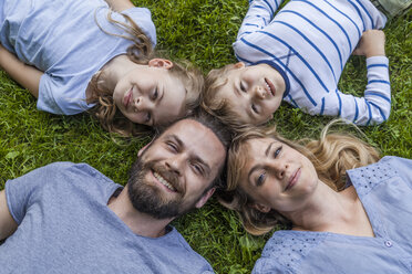 Porträt einer glücklichen Familie auf einer Wiese - TCF05437