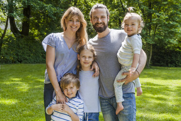 Portrait of happy family standing on meadow - TCF05438