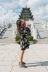 Südkorea, Seoul, Frau hält und küsst ein kleines Mädchen vor dem Nationalen Volkskundemuseum von Korea im Gyeongbokgung-Palast - GEMF01690