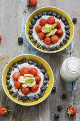 Two bowls of spelt pops with blueberries, strawberries, bananas and coconut flakes - ODF01529