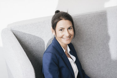 Portrait of smiling businesswoman on a couch - JOSF01168