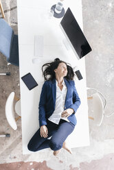 Geschäftsfrau liegend auf dem Schreibtisch im Büro - JOSF01192