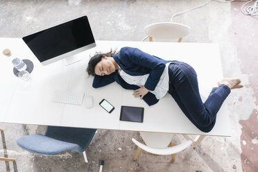 Geschäftsfrau schläft auf dem Schreibtisch im Büro - JOSF01194