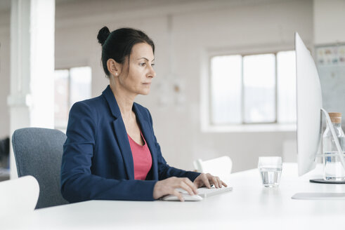 Frau arbeitet am Schreibtisch in einem Loft - JOSF01198