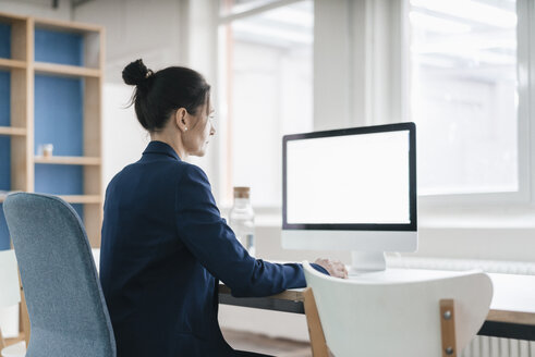 Frau arbeitet am Schreibtisch in einem Loft - JOSF01199