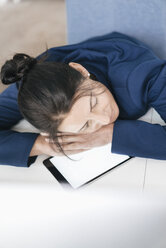 Overworked woman sleeping on tablet in office - JOSF01211