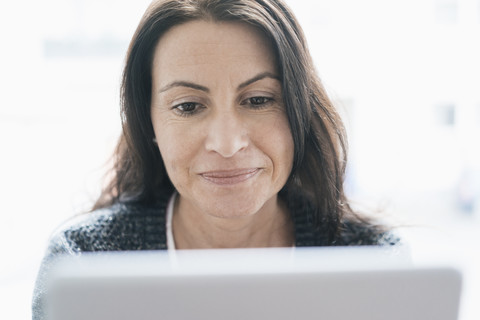 Porträt einer Frau mit Blick auf ein Tablet, lizenzfreies Stockfoto