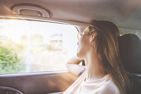Frau reist im Auto auf dem Rücksitz, lizenzfreies Stockfoto